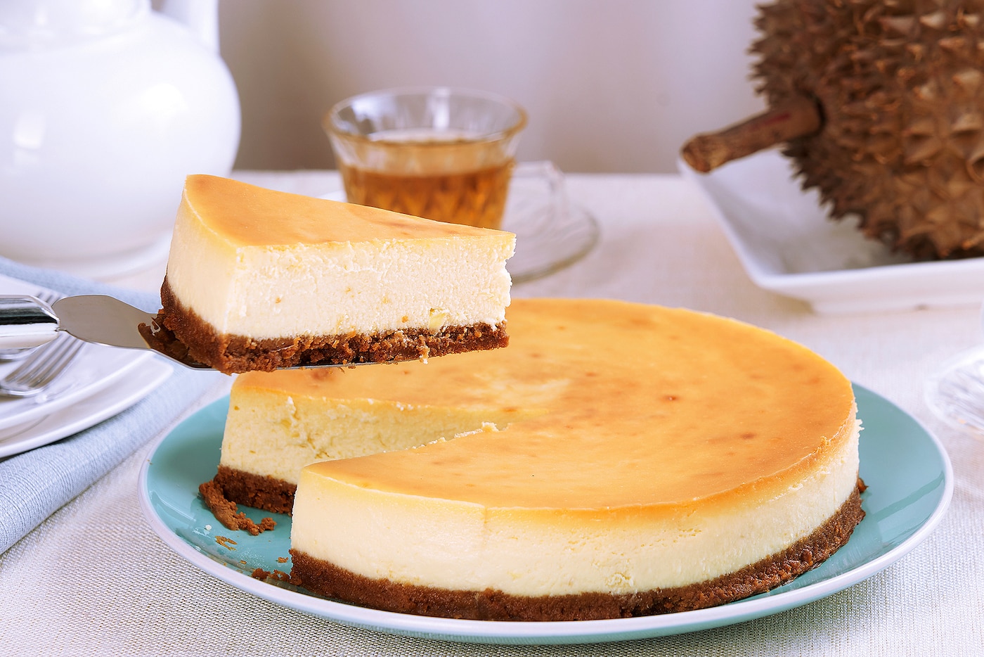 Durian Cheesecake yang Lezat: Sepotong durian cheesecake dengan lapisan krim keju yang lembut dan aroma durian yang khas